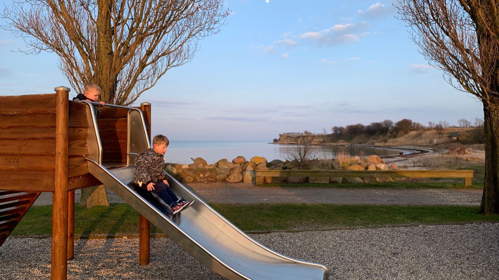 Børn rutsjer på legeplads